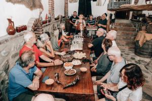 a group of people sitting around a table with food at Gugoshvili's Cellar in Kvareli +205 photos