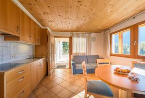 a kitchen and living room with a table and a dining room at AppartmentPircher 2 in Siusi