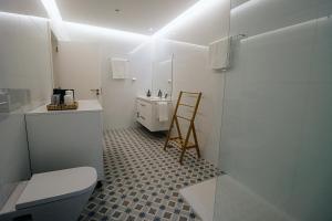 a bathroom with a toilet and a sink and a mirror at Peace In Azores 02 in Ribeira Grande