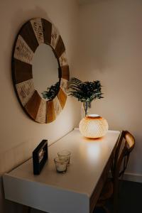 a table with a mirror and a vase on it at Peace In Azores 02 in Ribeira Grande
