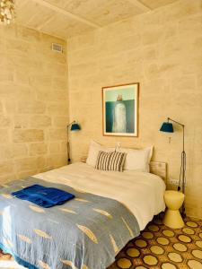 a bedroom with a large bed with two lamps at Nelli's B&B in Cospicua
