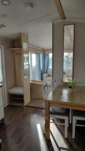 a living room with a wooden table and a dining room at Driftwood at Freshwater Beach Holiday Park in Burton Bradstock