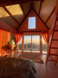 a bedroom with a bed and a large window at The Mystic Loft in Dharamshala