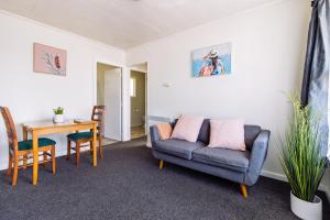 a living room with a couch and a table at Belle Bonne Motel in Christchurch +44 photos