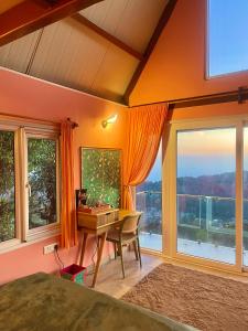 a bedroom with a desk and a large window at The Mystic Loft in Dharamshala