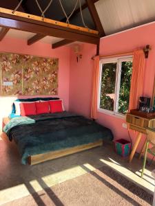 a bedroom with a large bed in a pink room at The Mystic Loft in Dharamshala