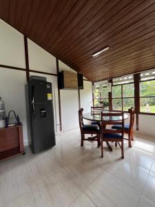 a dining room with a table and a refrigerator at Villa Del Viento in Calima