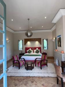 a bedroom with a large bed and two chairs at Privat Villa in Marrakesch with Pool & Garten in Marrakesh