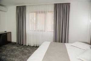 a bedroom with a white bed and a window at Motel Moara Veche in Săcălăşeni +55 photos