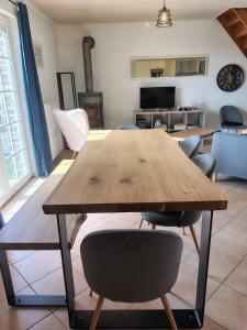 a wooden table and chairs in a living room at La petite maison de Terre de Partage in Ohey +6 photos