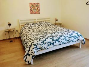 a bedroom with a bed with a blue and white comforter at La petite maison de Terre de Partage in Ohey
