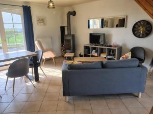 a living room with a blue couch and a table at La petite maison de Terre de Partage in Ohey