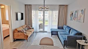 a living room with a blue couch and chairs at Thalassa Beach Resort - 107 in Vokolidha