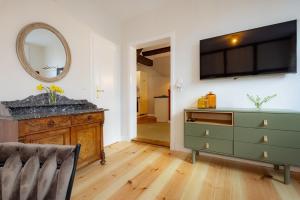 a living room with a dresser and a tv at Brauhaus am Schloss in Gartow