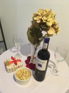a table with a bottle of wine and a vase with flowers at Terraza Hotel Villavicencio in Villavicencio
