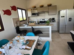 a kitchen with a table with chairs and a refrigerator at Brisas Vista Serena in Nueva Gorgona