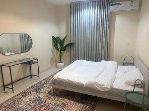 a bedroom with a bed and a table and a mirror at أستديو كلاود السحاب in Al Baha