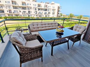 a patio with a table and chairs on a balcony at Thalassa Beach Resort - 107 in Vokolidha +46 photos