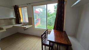 a room with a wooden table and a window at Eagle's Nest Inn in Cabangusan +15 photos