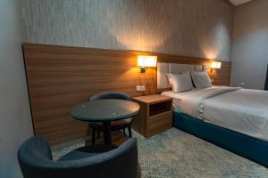 a hotel room with a bed and a table and chairs at Nozol Tabba in Medina