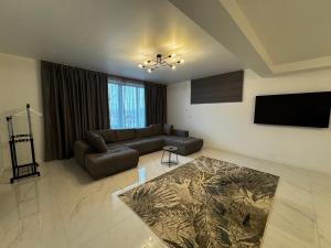 a living room with a couch and a flat screen tv at PET apartments in Râmnicu Vâlcea