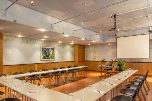 a conference room with tables and chairs and a whiteboard at Hotel Sanpi Milano in Milan