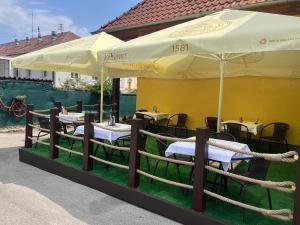 a group of tables with umbrellas in front of a building at Brasserka in Nitra