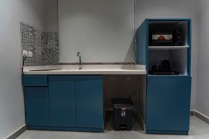 a kitchen with blue cabinets and a sink at Nozol Tabba in Medina +66 photos