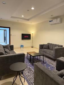 a living room with two couches and a tv at أستديو كلاود السحاب in Al Baha