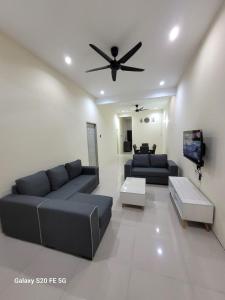 a living room with a couch and a ceiling fan at Rizqullah Homestay Ipoh in Ipoh +5 photos