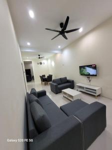 a living room with a couch and a ceiling fan at Rizqullah Homestay Ipoh in Ipoh