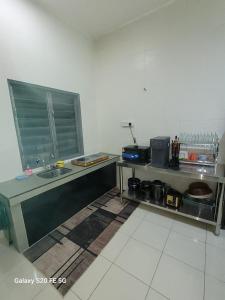 a kitchen with a counter and a sink in a room at Rizqullah Homestay Ipoh in Ipoh