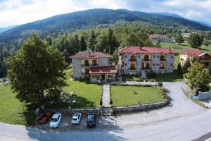 Luftaufnahme eines großen Hauses mit davor geparkten Autos. in der Unterkunft Orama Hotel - Serene Lake Plastira Retreat with Stunning Views in Kryonérion