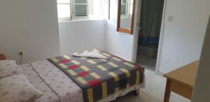 a room with a bed with a blanket on it at Residencial Bibi in Ribeira Grande