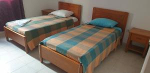 two beds sitting next to each other in a room at Residencial Bibi in Ribeira Grande