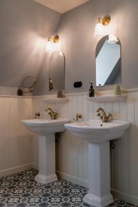 two sinks in a bathroom with two mirrors at Villa les Bruyères in Dilsen-Stokkem