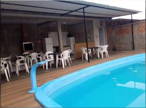 a swimming pool with a table and chairs next to it at QUARTO CONTEINER, EDICULA ABERTA E PISCINA AQUAVibes in Cascavel