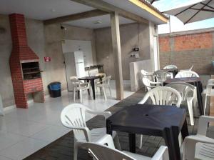 a restaurant with tables and white chairs and a fireplace at QUARTO CONTEINER, EDICULA ABERTA E PISCINA AQUAVibes in Cascavel