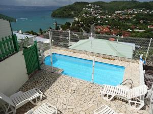 un balcón con sillas y una piscina en una casa en Les Gites Josiane en Les Trois-Îlets