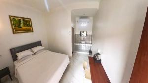 a bedroom with a white bed and a wooden table at Arka Homestay Pesagi in Karangasem +14 photos