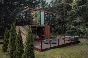 a tree house with a deck and a glass box at Kihnuvillas - Männirahu in Linaküla +14 photos
