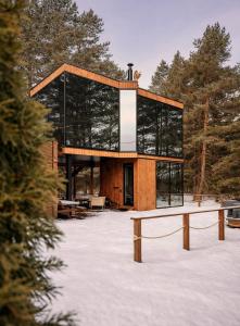 a glass house with a bench in the snow at Kihnuvillas - Männirahu in Linaküla