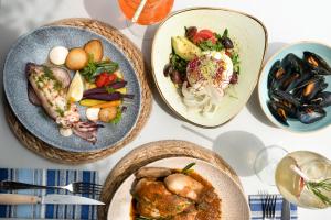 a table with three plates of food on it at Hotel Menorca Binibeca - Adults Recommended - by Pierre & Vacances Premium in Binibeca