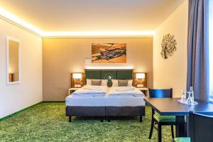 a hotel room with a bed and a desk and a table at Pension Augsburg Ost in Augsburg