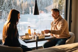 a man and a woman sitting at a table with food at Ådalsvollen Retreat -Go Wild for a While, Private Nature Getaway in Verdal
