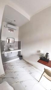 a white bathroom with a sink and a toilet at Arka Homestay Pesagi in Karangasem