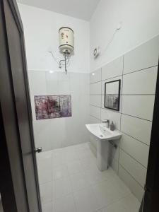 a white bathroom with a sink and a mirror at Auranest Stays Duplex Home in Ludhiana +20 photos