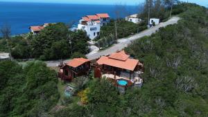 an aerial view of a house on a hill next to the ocean at Pousada e Restaurante Vista Turquesa in Arraial do Cabo