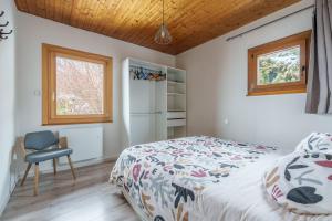 a bedroom with a bed and a chair and a window at Clairmatin - Plein Centre de La Bresse in La Bresse