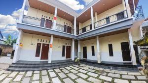 a large building with doors and a courtyard at Arka Homestay Pesagi in Karangasem